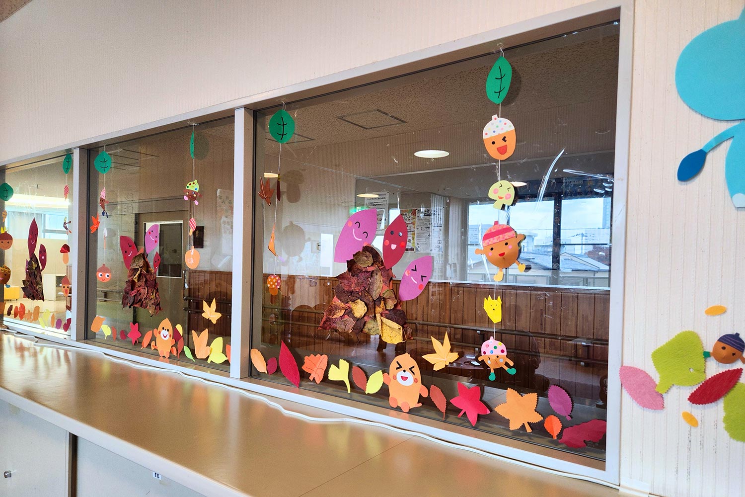 焼き芋や紅葉など季節の装飾を施した窓