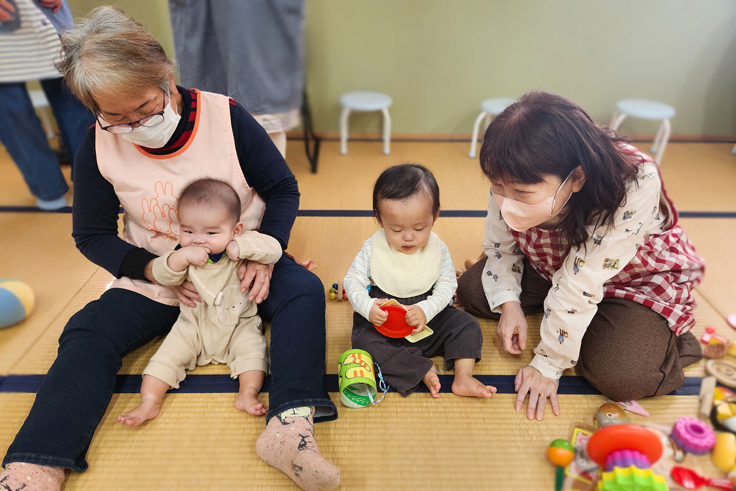 託児室でこどもをあやすスタッフたち