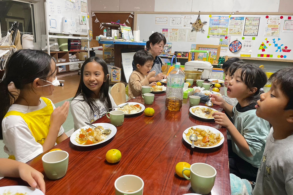 夕食を皆で食べているこどもたち
