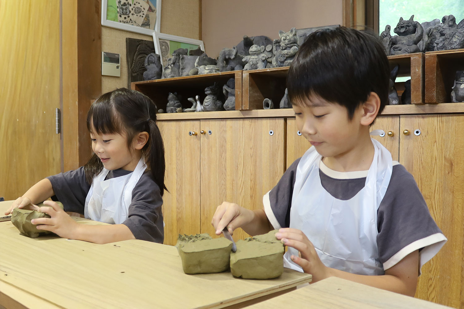 粘土を前に何を作ろうかと考えているこどもたち