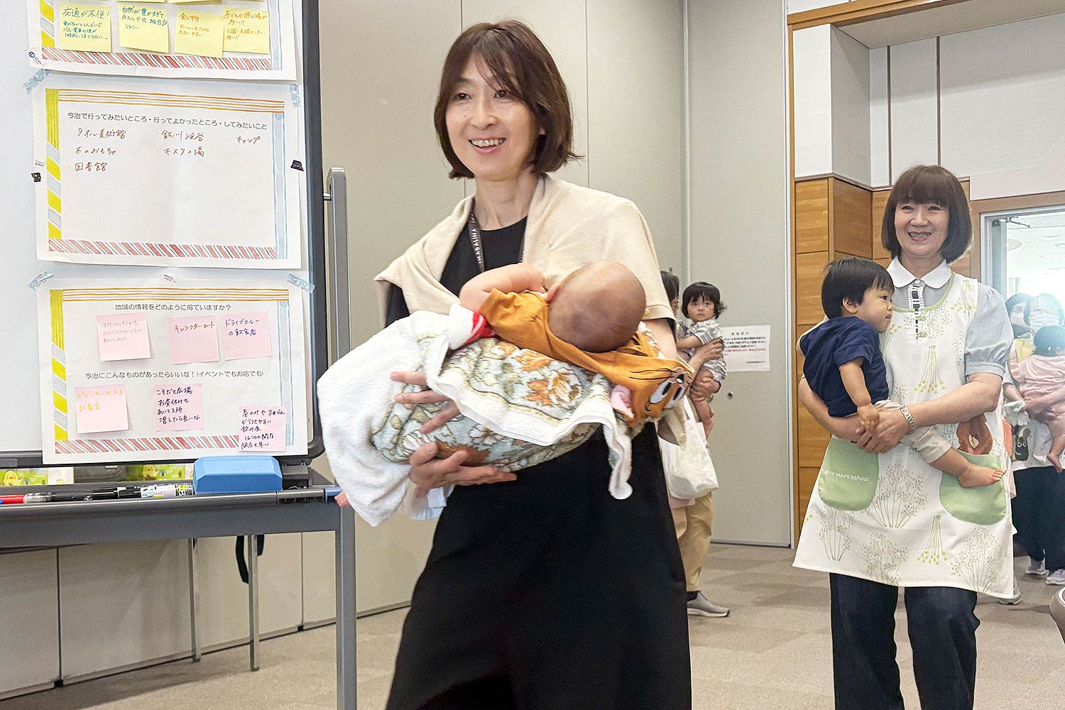 スタッフがこどもをおくるみ抱っこしている様子