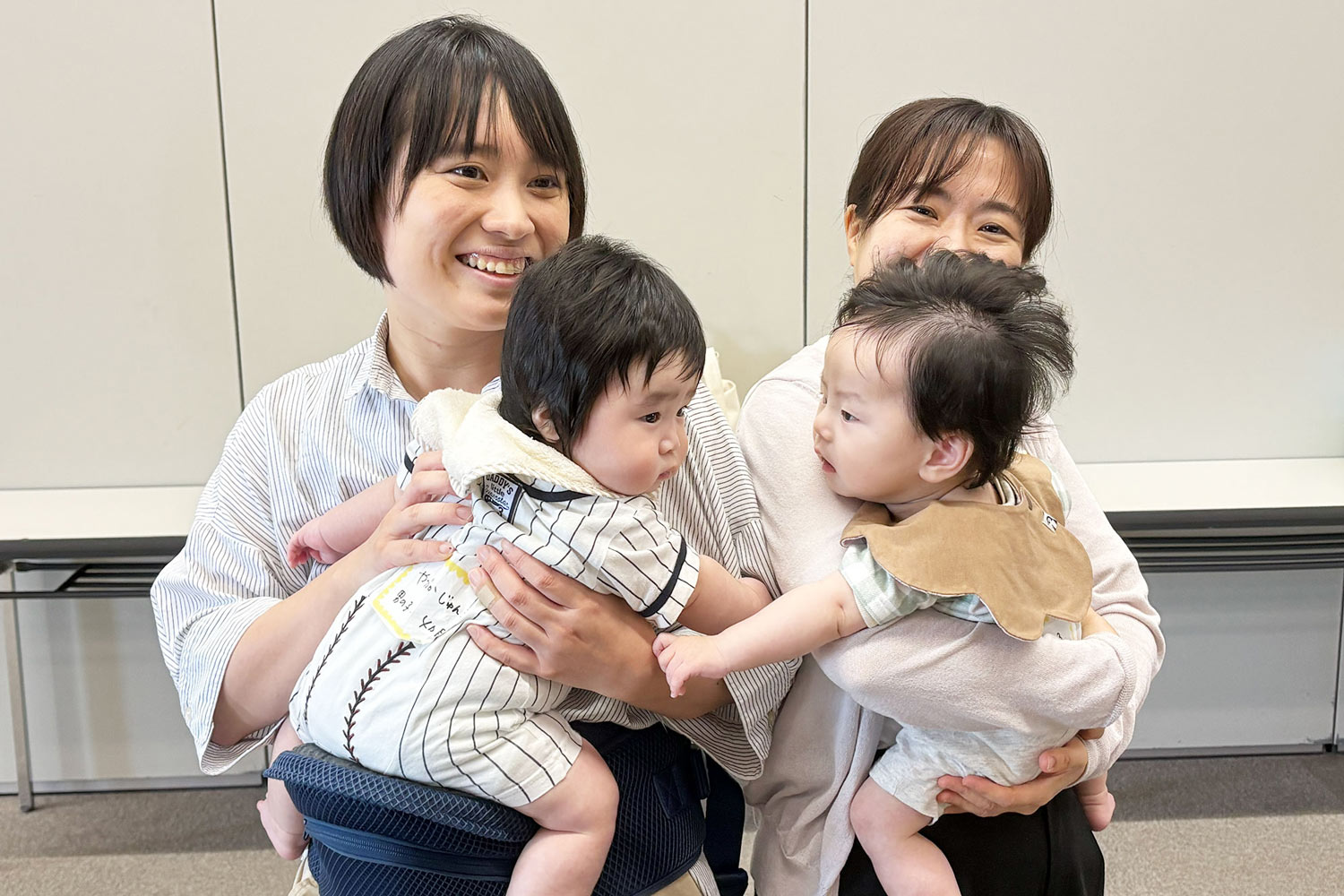 2人のお母さんがそれぞれこどもを対面抱っこしている様子
